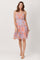 woman wearing a floral patterned spaghetti strap summer dress in pastel colors