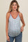 woman wearing a light blue floral maternity tank top with a v-neck and burgundy trim, showing her baby bump