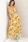 woman wearing a yellow floral crop top and matching maxi skirt, paired with green sneakers