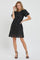 woman wearing a black lace short sleeve dress with a scalloped hem and a fitted silhouette