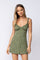 woman wearing a green floral print mini dress with ruffled straps and a fitted bodice