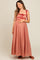 woman wearing a rose-colored maternity maxi dress with adjustable straps and a cinched bodice, holding her baby bump