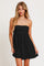 woman wearing a black strapless mini dress with a flowy skirt and layered necklaces