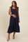 woman wearing a navy blue maternity dress with ruffle sleeves and a tiered skirt, showing her baby bump