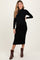 woman wearing a black ribbed maternity dress with long sleeves and a fitted silhouette, showing her baby bump