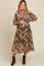 woman wearing a floral printed maternity dress with puffed sleeves and a tie neckline, highlighting her baby bump