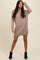 woman wearing a taupe turtleneck sweater dress with ribbed details and long sleeves