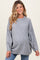 woman wearing a gray oversized maternity sweater with batwing sleeves and a visible baby bump