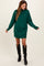 woman wearing a green oversized sweater dress paired with black knee-high boots