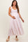 woman wearing a pink and white floral patterned maternity maxi dress with tie straps and holding her baby bump
