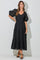 woman wearing a black tiered midi dress with puff sleeves and a v-neckline, styled with black strappy heels