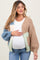 woman wearing a multicolored chunky knit maternity cardigan and holding her baby bump