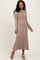 woman wearing a taupe ribbed midi dress with long sleeves and a fitted silhouette, paired with beige block-heeled sandals