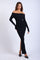 woman wearing a black off-the-shoulder ribbed maxi dress with long sleeves and a thigh-high slit