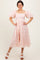woman wearing a pink floral midi dress with puff sleeves and a square neckline
