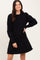 woman wearing a black long sleeve sweater dress with puffed sleeves