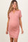 woman wearing a pink short sleeve maternity dress with button details and a visible baby bump