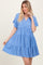 woman wearing a light blue tiered dress with short sleeves and a v-neckline