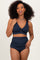 woman wearing a navy blue ribbed bikini set with a twist front top and high-waisted bottoms