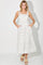 woman wearing a white floral midi dress with spaghetti straps and pockets, standing with hands in pockets