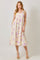 woman wearing a flowy yellow maxi dress with purple floral print and thin straps