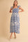 woman wearing a white and blue floral print maxi dress with ruffle sleeves and a fitted bodice