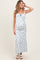 woman wearing a white floral maternity maxi dress with adjustable straps and a visible baby bump
