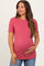 woman wearing a raspberry ribbed maternity top with scalloped edges and holding her baby bump
