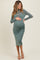 woman wearing a teal long sleeve fitted maternity dress with ruching, gently holding her baby bump