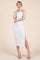woman wearing a white ribbed halter neck midi dress with a side slit and strappy heels
