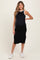 woman wearing a black maternity midi dress with white trim and a visible baby bump, paired with white sneakers