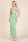 woman wearing a mint green spaghetti strap maxi dress with ruching details
