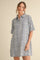 woman wearing a short-sleeve striped oversized shirt dress in blue and white