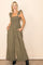 woman wearing an olive green smocked jumpsuit with ruffle straps and side pockets