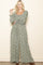woman wearing a green floral long sleeve jumpsuit with a square neckline and a relaxed fit
