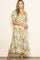 woman wearing a yellow floral midi dress with puff sleeves and a square neckline, standing against a light background