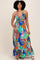 woman wearing a colorful floral maxi dress with a halter neckline and ruffled hemline
