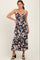 woman wearing a navy blue and cream floral midi dress with adjustable straps and a front tie detail