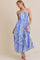 woman wearing a blue and white floral maxi dress with spaghetti straps and a fitted bodice