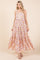 woman wearing a pink floral maxi dress with a tiered skirt and spaghetti straps