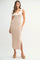 woman wearing a cream and beige knit maxi dress with tie shoulder straps and a v-neckline