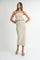 woman wearing a beige strapless ribbed two-piece set with a ruffled crop top and a midi skirt