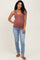 woman wearing a rust-colored maternity tank top and blue skinny jeans, showing her baby bump