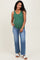 woman wearing a green ribbed maternity tank top and blue flared jeans, showing her baby bump