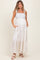 woman wearing a floral print maternity maxi dress with bow straps and pockets, showcasing her baby bump