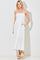 woman wearing a white polka dot maxi dress with adjustable straps and pockets, styled with beige slide sandals
