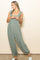 woman wearing a green floral print jumpsuit with ruffled straps and wide-leg pants