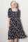woman wearing a black floral midi dress with puff sleeves and a square neckline