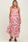 woman wearing a floral patterned maternity maxi dress with adjustable straps and a flowy skirt, showcasing her baby bump