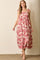 woman wearing a pink floral maxi dress with tie straps and a tiered skirt